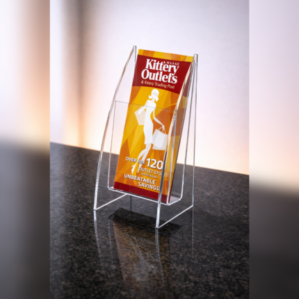Clear acrylic angled flyer holder on a countertop displaying a promotional leaflet, designed for neat and visible brochure or flyer presentation