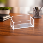 Clear acrylic business card holder placed on a desk, designed to neatly store and display business cards for easy access in offices or reception areas